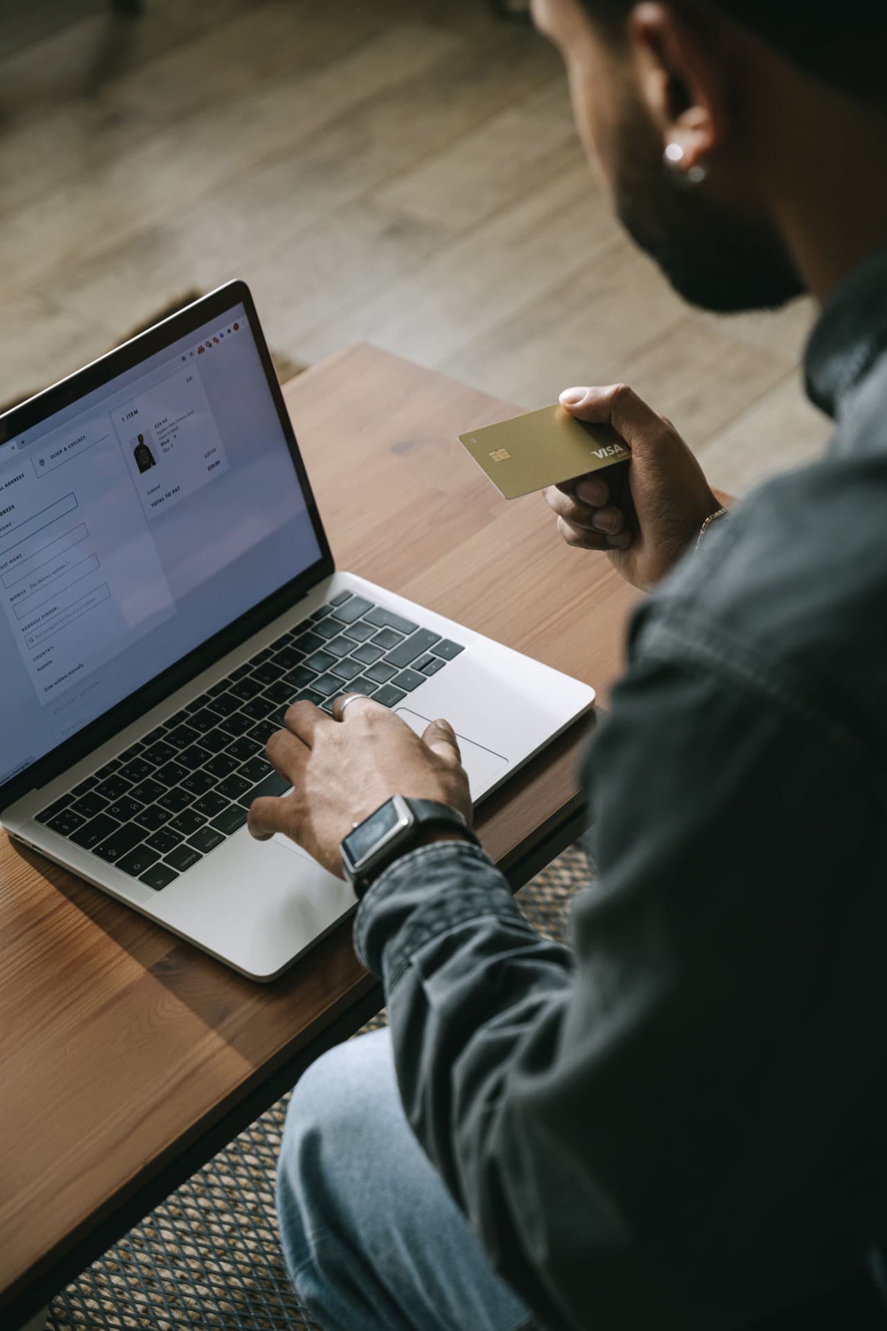 Store owner managing an online purchase from a laptop